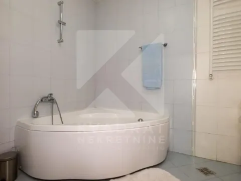 Kupatilo opremljeno ugaonom kadom i bijelim keramičkim pločicama. - image 14