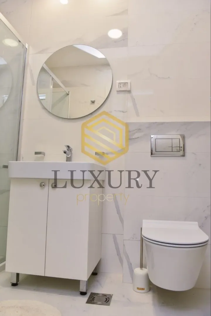 Modernly equipped bathroom with a washbasin and toilet.