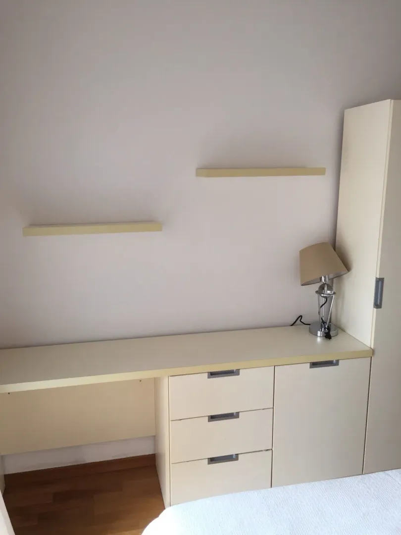 Radni sto sa fiokama, policama i lampom u spavaćoj sobi.
