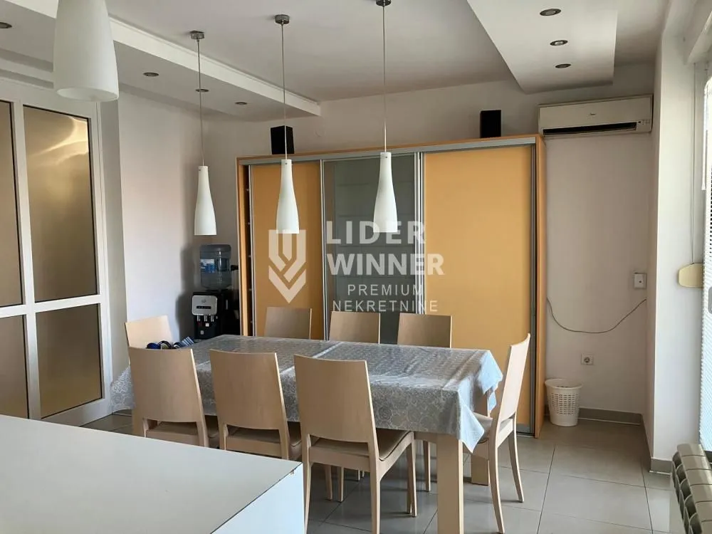 Dining area with a table, chairs, and a large wardrobe in the background.