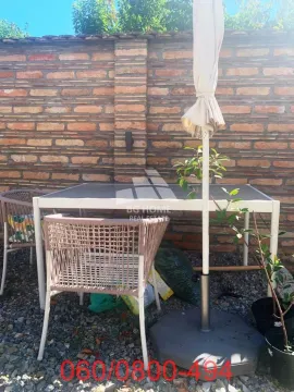Baštenska garnitura sa stolom i stolicama ispred zidane ograde. - image 13