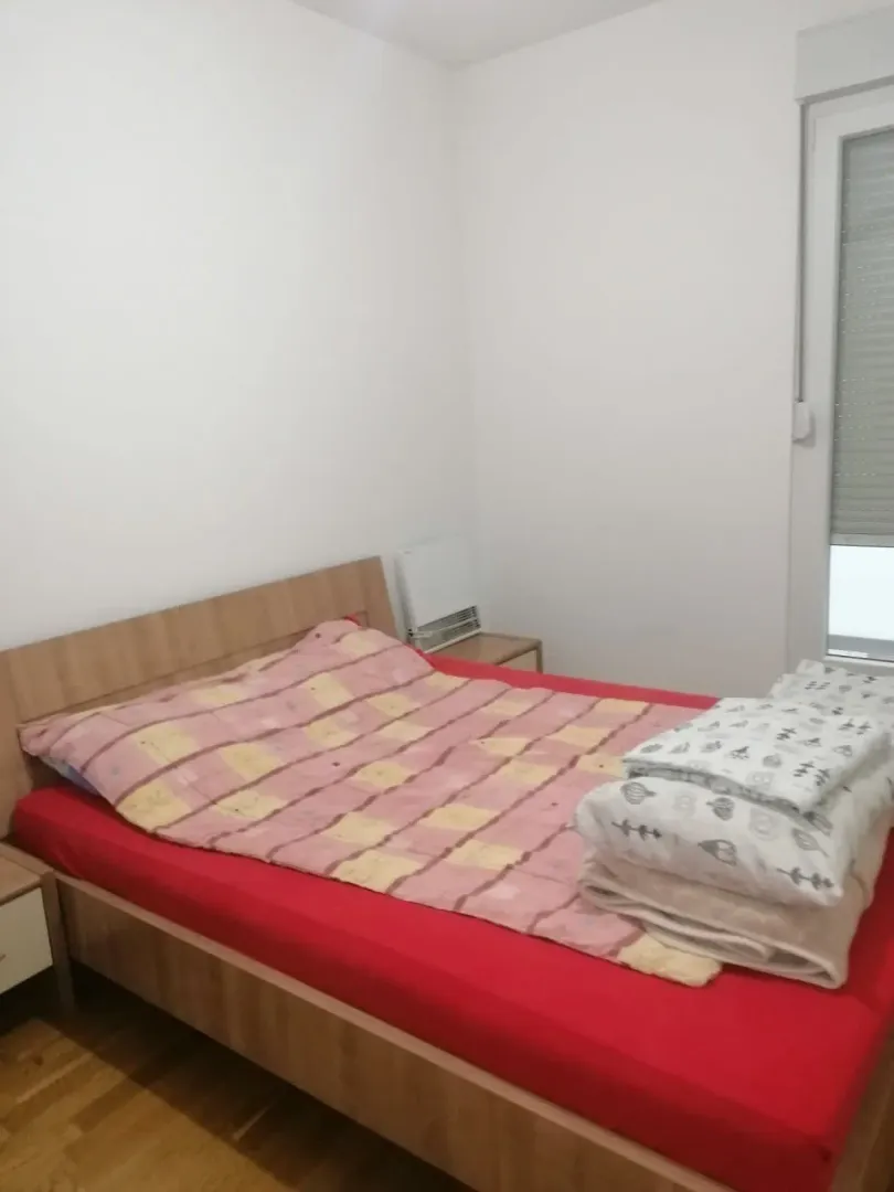 Jednostavno namještena spavaća soba sa bračnim krevetom.