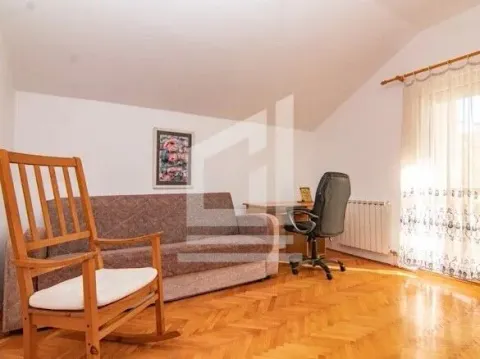 Living room with a sofa, a wooden rocking chair, and a desk. - image 9