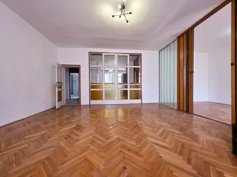 Empty living room with herringbone parquet flooring and wooden interior partitions. - image 2