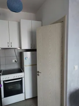 Manja kuhinja sa bijelim elementima, frižiderom i šporetom. - image 5