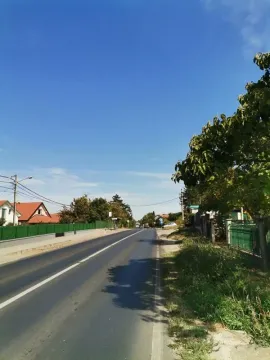 Pogled na asfaltirani put i okolne kuće sa zelenilom. - image 2