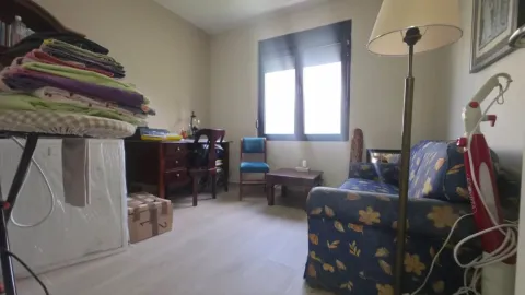 Dnevna soba sa kaučem, radnim stolom i gomilom stvari na daski za peglanje. - image 13