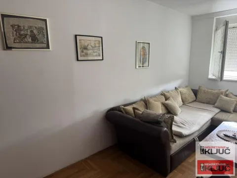 Dnevna soba sa ugaonom garniturom i slikama na zidu. - image 3