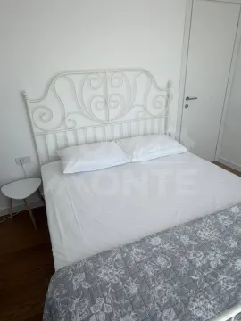 Bright bedroom with a white bed and light interior. - image 4