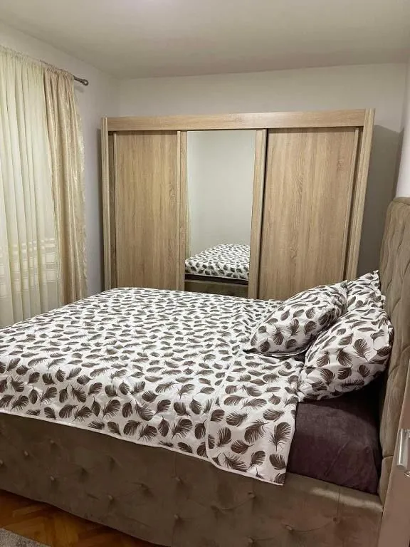 Furnished bedroom with a double bed and a large wardrobe.