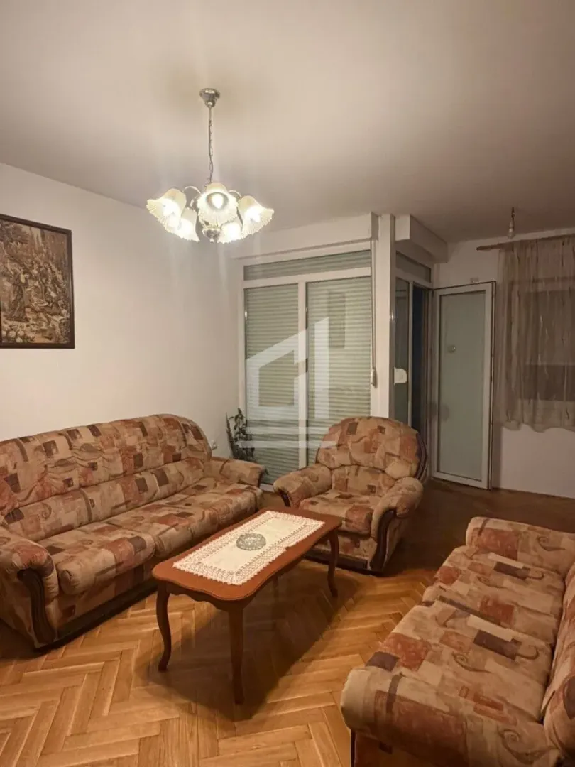 Living room with a seating set, a coffee table and wooden flooring.