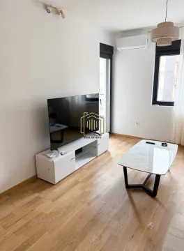 Living room with a television, low TV unit, and a coffee table. - image 6