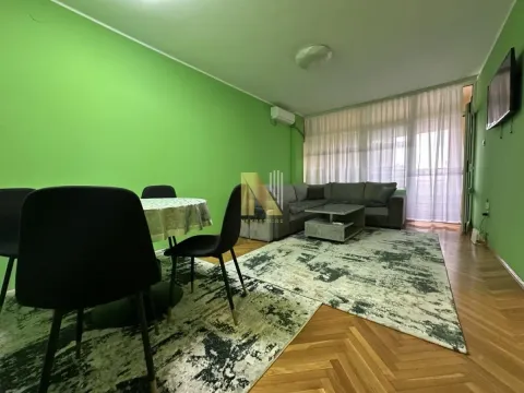 Living room with a sofa, dining table, and green walls. - image 2