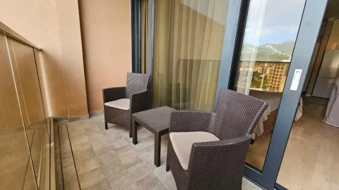 Small balcony with seating furniture and a view of the surroundings. - image 12
