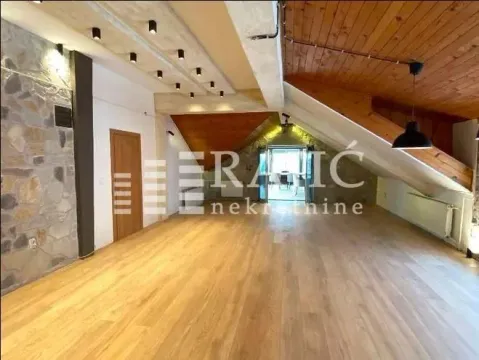 Spacious living room with wooden flooring and a sloped ceiling. - image 10