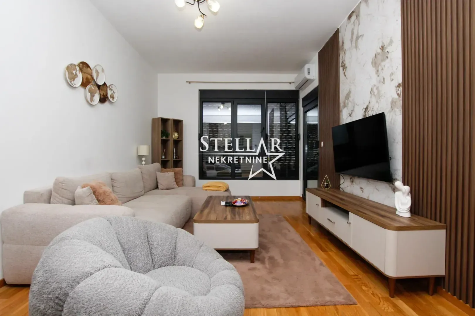 Living room with a sofa, television, and wooden wall accents.