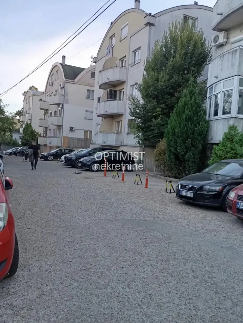 Pogled na spoljašnjost zgrade i parking ispred objekta.