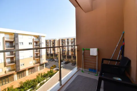 Manji namješteni balkon sa staklenom ogradom i pogledom na naselje. - image 11