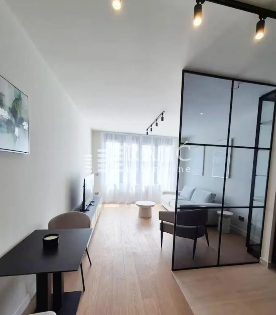 Modern living room with dining area and glass partition.