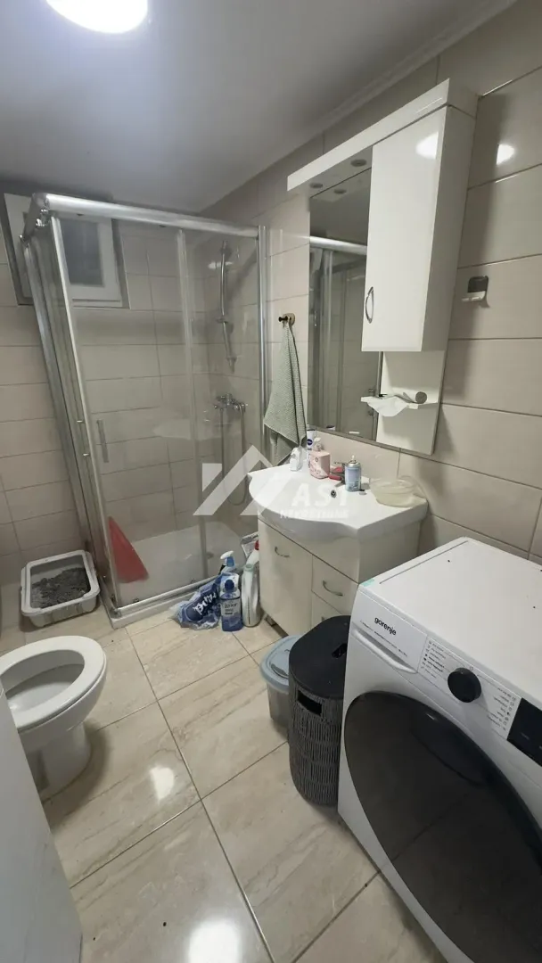 Bathroom equipped with a shower cabin, washbasin, toilet, and washing machine.