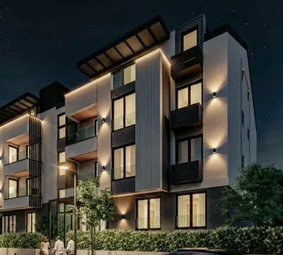 Noćni prikaz moderne stambene zgrade sa osvetljenjem i uređenim dvorištem. - image 6