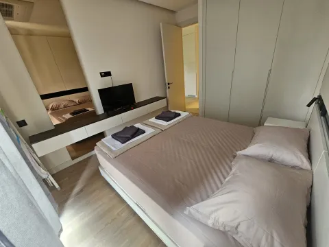 Modern bedroom with a double bed, wardrobe, and television. - image 8