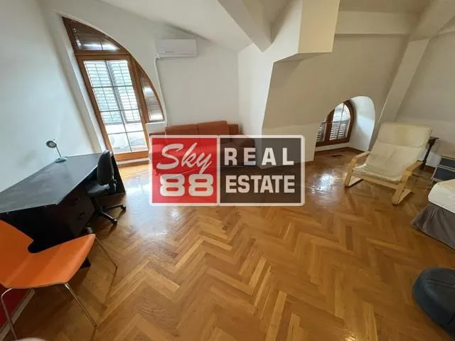 Living room with a desk and parquet flooring.