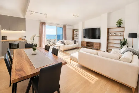 Spacious living room with an open-plan dining area and kitchen and a sea view. - image 3
