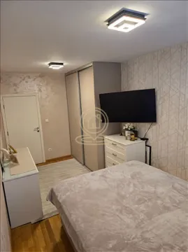 Nameštena spavaća soba sa bračnim krevetom, ormarom i televizorom na zidu. - image 5