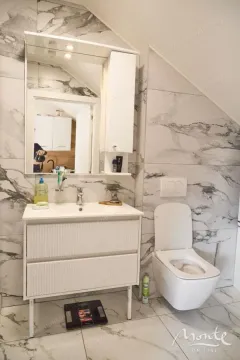 Moderne kupatilo sa umivaonikom, ogledalom i toaletom u potkrovlju. - image 14