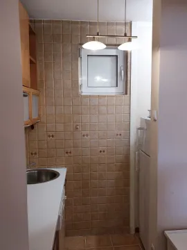 Mala, funkcionalna kuhinja sa svijetlim pločicama i ugradnim elementima. - image 13