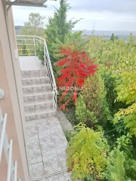 Spoljne stepenice sa terasom koje vode u dvorište puno zelenila. - image 7