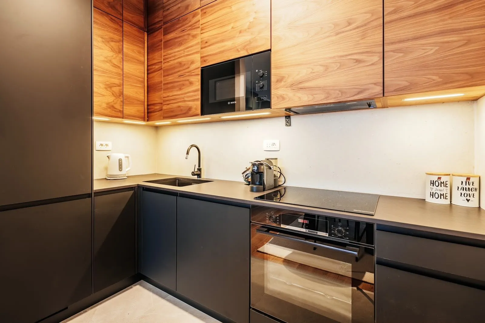 Modern kitchen with dark lower cabinets and wooden upper cabinets.