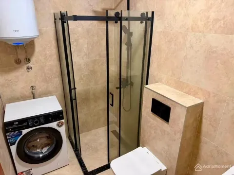 Kupatilo opremljeno tuš kabinom, wc šoljom i veš mašinom. - image 5
