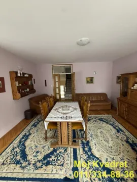 Dnevna soba sa trpezarijskim stolom, garniturom za sedenje i drvenim nameštajem. - image 17