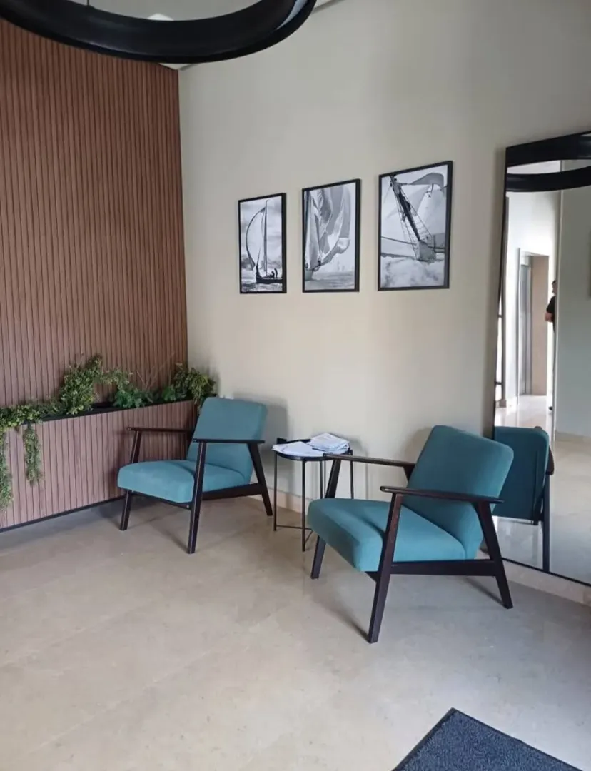 Living room with two armchairs, a small table, and pictures on the wall.