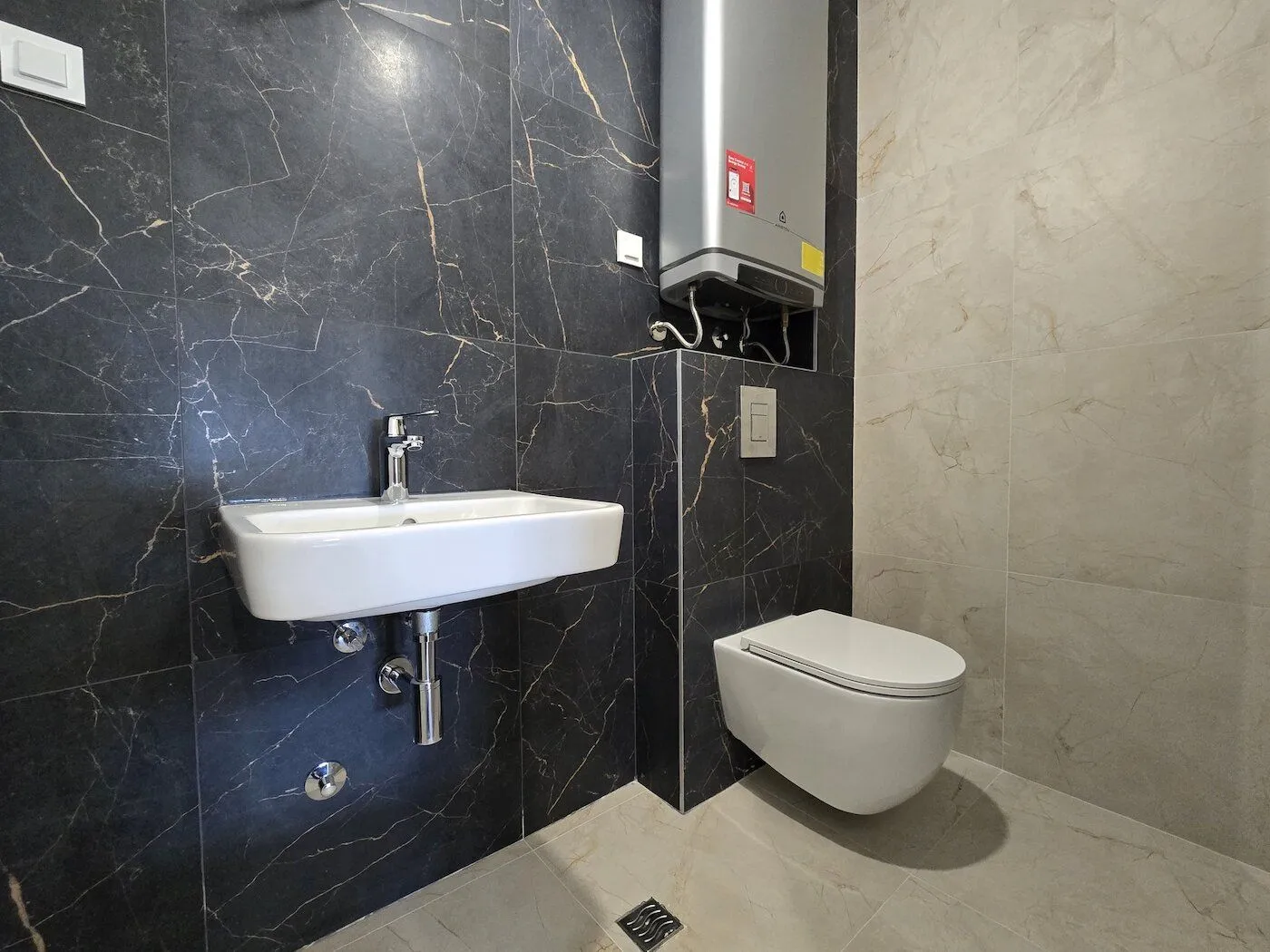 Modernly equipped bathroom with a washbasin and a wall-mounted toilet.