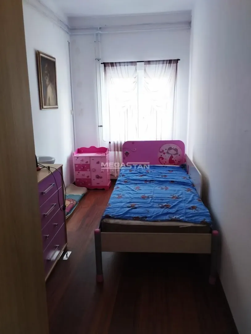 Dečja soba sa krevetom i komodom.