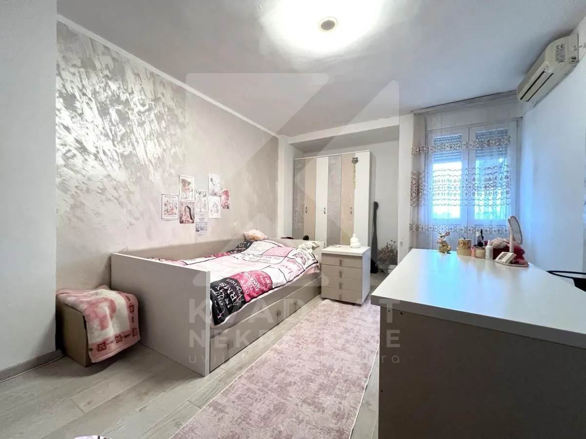 Children's bedroom with a bed, wardrobe, and desk.