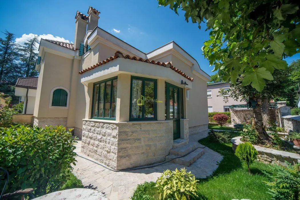 Exterior view of the house with a landscaped yard and greenery.