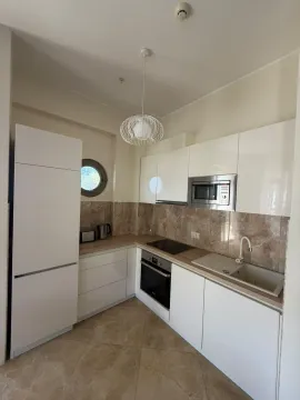 Modern white kitchen with built-in appliances. - image 8