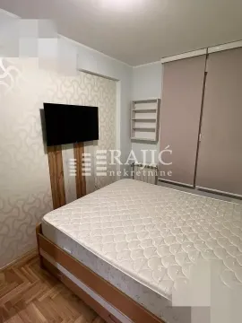 Bedroom with a double bed, wardrobe, and a wall-mounted TV. - image 12