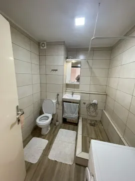 Bathroom equipped with sanitary ware, a washbasin, a shower, and a washing machine. - image 8
