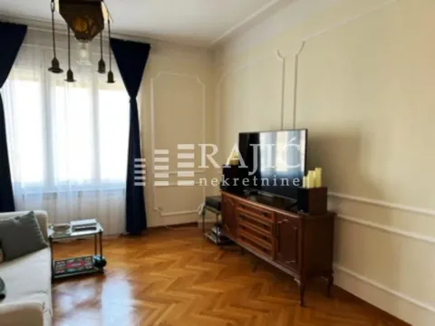 Living room with parquet flooring, furniture, and a television. - image 3