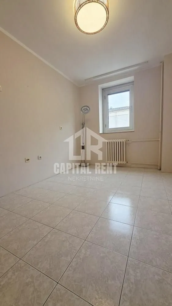 Empty room with tiled flooring, a window, and a radiator.