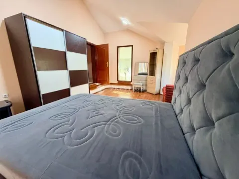Spacious bedroom with a large double bed, wardrobe, and a view of the bathroom. - image 15