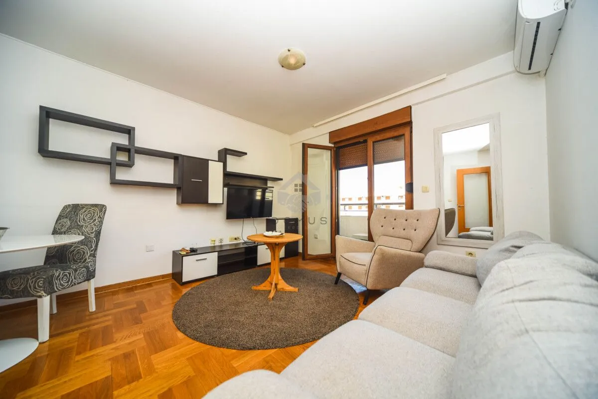 Living room with a sofa set, TV, dining table and access to the terrace.