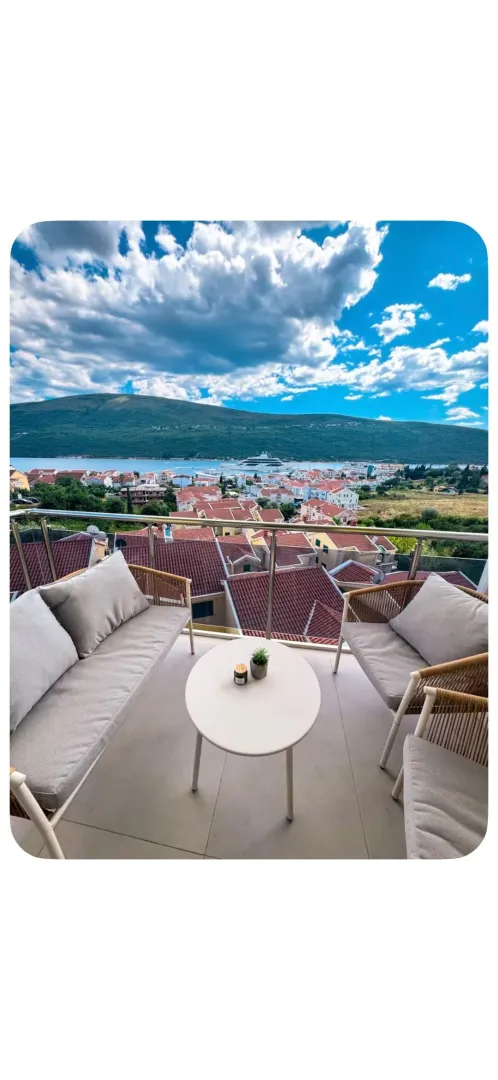 Namještena terasa sa garniturom za sjedenje i pogledom na more i grad.