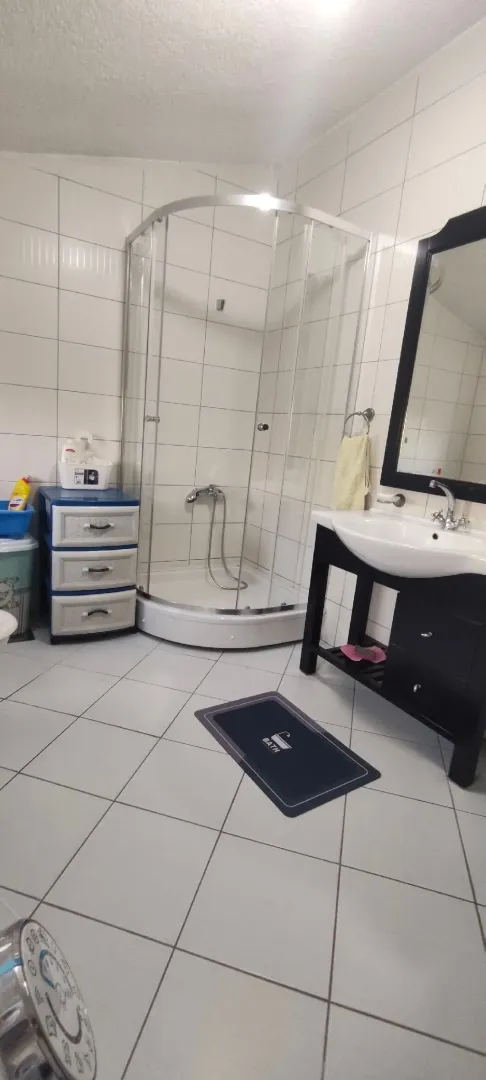 Bathroom with a shower cabin, sink, and mirror.