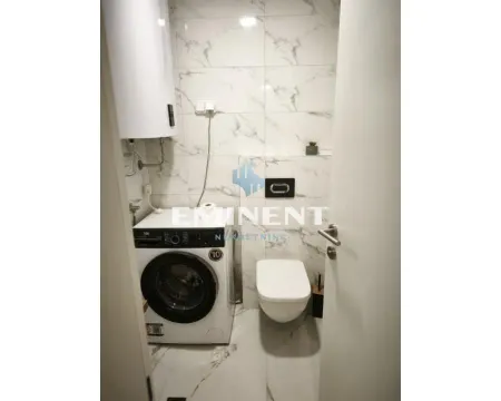 Small bathroom with a toilet, washing machine, and water heater. - image 4